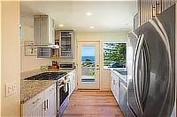 Kitchen with stainless steel appliances and door to the deck